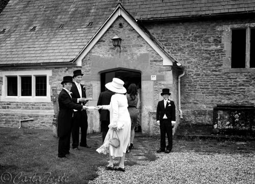 Black and white documentary picture of wedding guests arriving